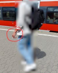 Ein Fahrgast raucht auf einem N&uuml;rnberger Bahnsteig, w&auml;hrend er an einem Zug entlanggeht
